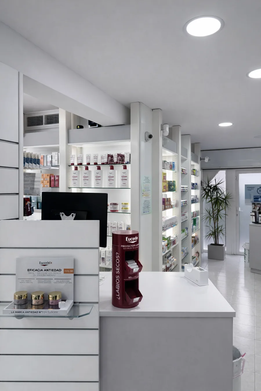 Interior de Farmacia MM — estanterías de dermocosmética y mostrador